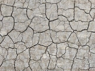 Dry cracked gray ground. Natural background. Chernozem and agriculture in the period of extreme drought. The texture of the desert close up. High quality photo