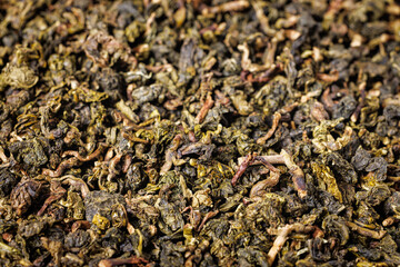 Dry green tea leaves with mango. Background close-up.