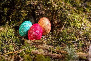 Drei leuchtende Ostereier im Wald versteckt