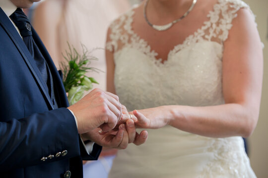 Homme qui passe la bague au doigt de sa future femme lors d'un mariage