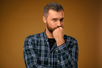 Handsome man with beard covering his mouth with one hand