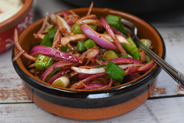 Pickled slliced onion in small clay dish