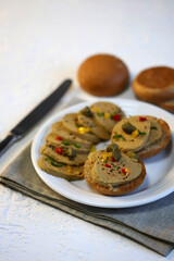 Liver pate with buns and spices on a plate.