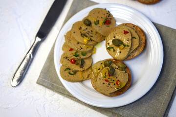 Liver pate with buns and spices on a plate.