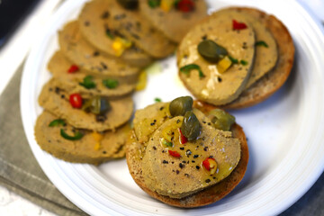 Liver pate with buns and spices on a plate.