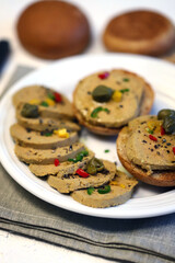 Liver pate with buns and spices on a plate.