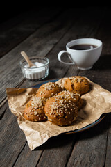 Cup of Black Coffee with a Bowl of Sugar and Baked Walnut Muffins on top of a Black Wood Tabletop