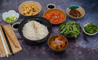 Make your own vegan bowl spread: rice noodles, tofu, kimchi, edamame, seitan