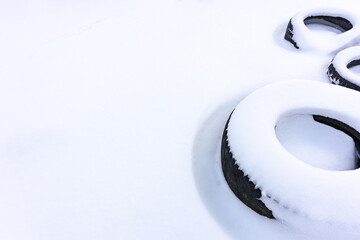 Tires covered with snow. Circles on a white field. Winter theme.