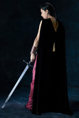 An elf warrior queen wearing a laced bodice and draped skirt and holding a sword
