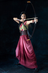 An elf warrior queen wearing a laced bodice and draped skirt and holding a bow and arrow