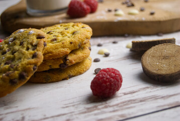 Baked biscuits with raspberries and milk with chocolate drops on the old wooden surface