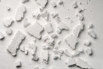 Broken pieces of white styrofoam on the sheet of white styrofoam