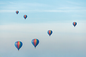 Large balloons float against the background of the blue sky. The concept of aeronautics.
