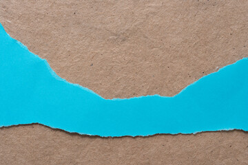 torn blue paper on plain brown background