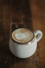 Isolated Cappuccino in White Mug Against Dark Wood Table. Moody Coffee Shop Lifestyle. Coffee Flat Lay with Copy Space. Cortado. Flat White.