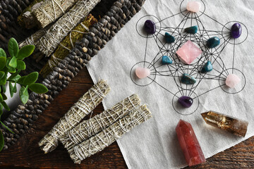 A top view image of a healing crystal grid using a sacred geometry grid cloth and white sage smudge...