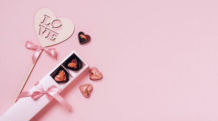 Festive composition for Valentine's Day. Chocolate candy hearts satin summer on a pink background. Flat