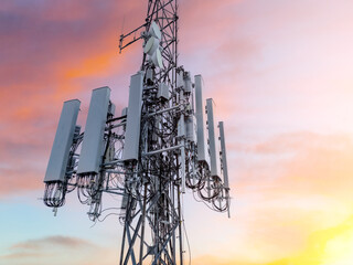 5G cell tower at sunset. Close up photo cellular antennas on a cell site radio mast. - obrazy, fototapety, plakaty