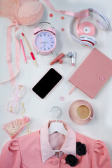 Naklejka na ściany i meble womens stylish accessories, smartphone with blank screen, glamorous set in pink shades, flat lay, copy background, womens clothing, alarm clock, lipstick, coffee cup, good morning concept, female life