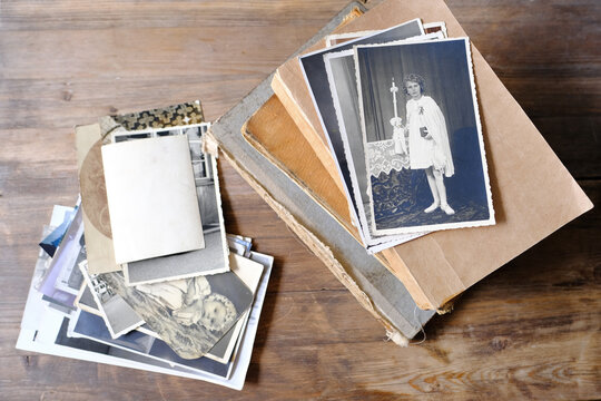 stack of vintage photos, retro photography of 1940-1950 on wooden table, old books, concept of genealogy, memory of ancestors, family tree, genealogy, childhood memories, family archive