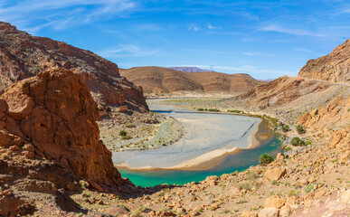 The turquoise blue of the ziz river gorge is a stark contrast to the desert rock in the high Atlas Mountains of Morocco