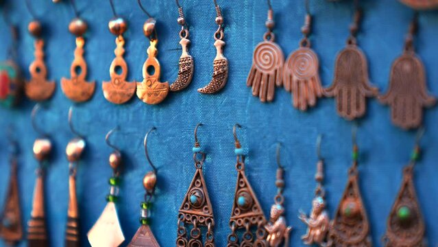 Rows of handmade traditional earrings jewellery and souvenirs displayed for sale at marketplace