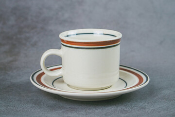 coffee cup with plate on gray background