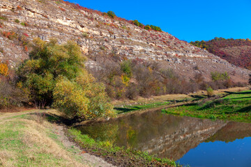 Flowing small river near hill . Rocky riverside hill scenery 