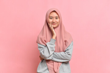 Happy and joyful look of  Young Asian Muslim woman with beautiful smile touch her cheek