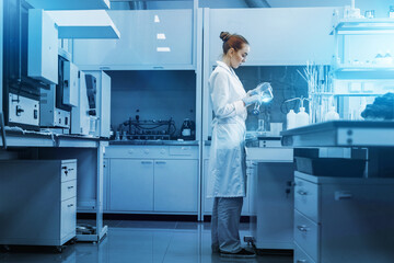 Professional female scientist is working on a vaccine in a scientific research laboratory. Genetic engineer workplace. Technology and science concept. Stop COVID-19