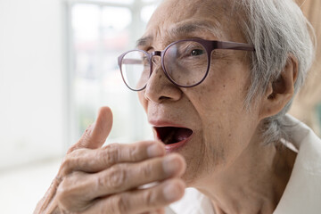 Asian senior woman checking breath with hand,old elderly doing a bad breath test,foul mouth from...