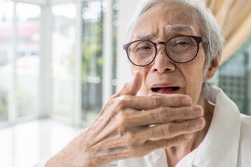 Asian senior woman checking breath and breathe,old elderly have bad breath,bad smell,stink,foul...