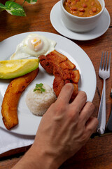 Hand Holding fried pork and sweet plantain for breakfast