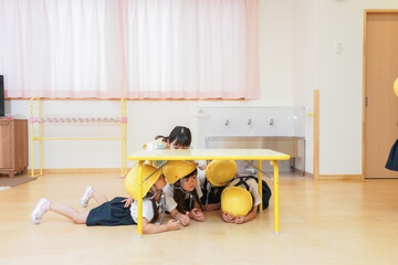 ヘルメットを被り避難する子供