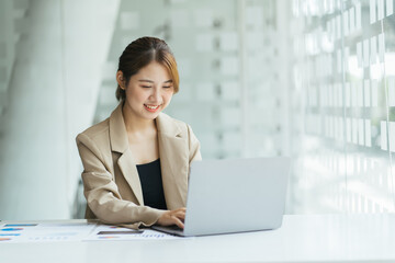 Portrait of smiling beautiful business asian woman working in office use computer with copy space....