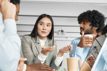 Young asian woman telling opinion speaking to multi-ethnic diverse colleagues