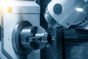 Fototapeta premium The multi-axis CNC lathe machine cutting the metal gear part.