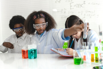 Group of teenage cute little student child learn science research and study doing a chemical science experiment making analyzing and mix liquid in test tube on class at school.Education