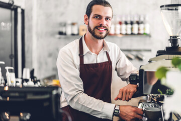 Portrait of smile handsome bearded barista man startup small business owner working and look at camera receive order from customer behind the counter bar in a cafe - obrazy, fototapety, plakaty