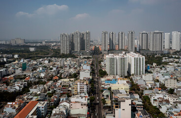 Fototapeta premium Sunny day aerial view of modern city real estate development with terrace houses, villas and high rise buildings with green space
