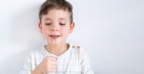Cute boy pulling loose tooth using a dental floss. The boy's first milk tooth is loose. Toothache. Process of removing a baby tooth. Emotions of a child