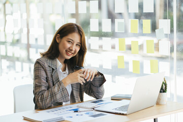 Asian woman working on a laptop computer,Working in the office with laptop concept,Young Asian woman starting a business using a laptop computer.