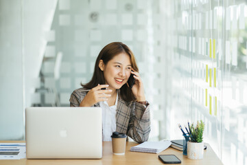 Laughing female entrepreneur talking with a client on her cellphone