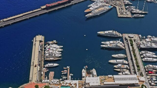 Monaco Aerial v23 birds eye view drone fly across the touristic luxury neighborhoods capturing yachts docked at port hercule, famous casinos and downtown cityscape - July 2021