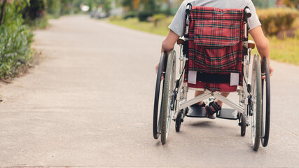 Obraz premium Young man with a disability learn how to use wheelchairs on the road by him self, Lifestyle in the education age of teenager boy, Traveling in vehicles for people with disabilities concept.