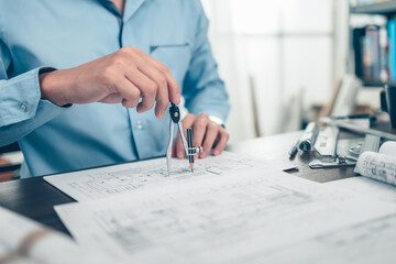 Architect engineer use compass drawing design working on bueprint. House planning design and...