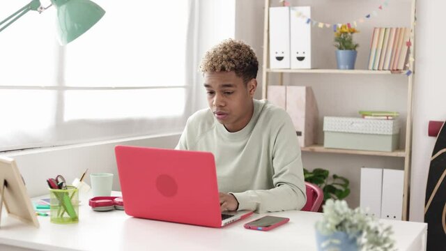 Disappointed hispanic latin teenager boy consulting exam notes in school campus online - Young student reading bad news on laptop - Fail an exam, education and learning online concept. 
