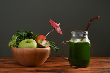 Fresh green smoothie in glass with ingredients on wooden table. Detox healthy drinks concept.