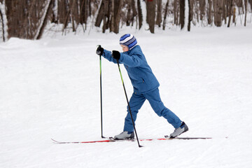 A boy in blue clothes is skiing